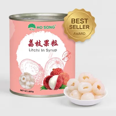 Pink-labelled Ho Song can of litchi in syrup, 850 grams, beside a white bowl of peeled whole lychees.